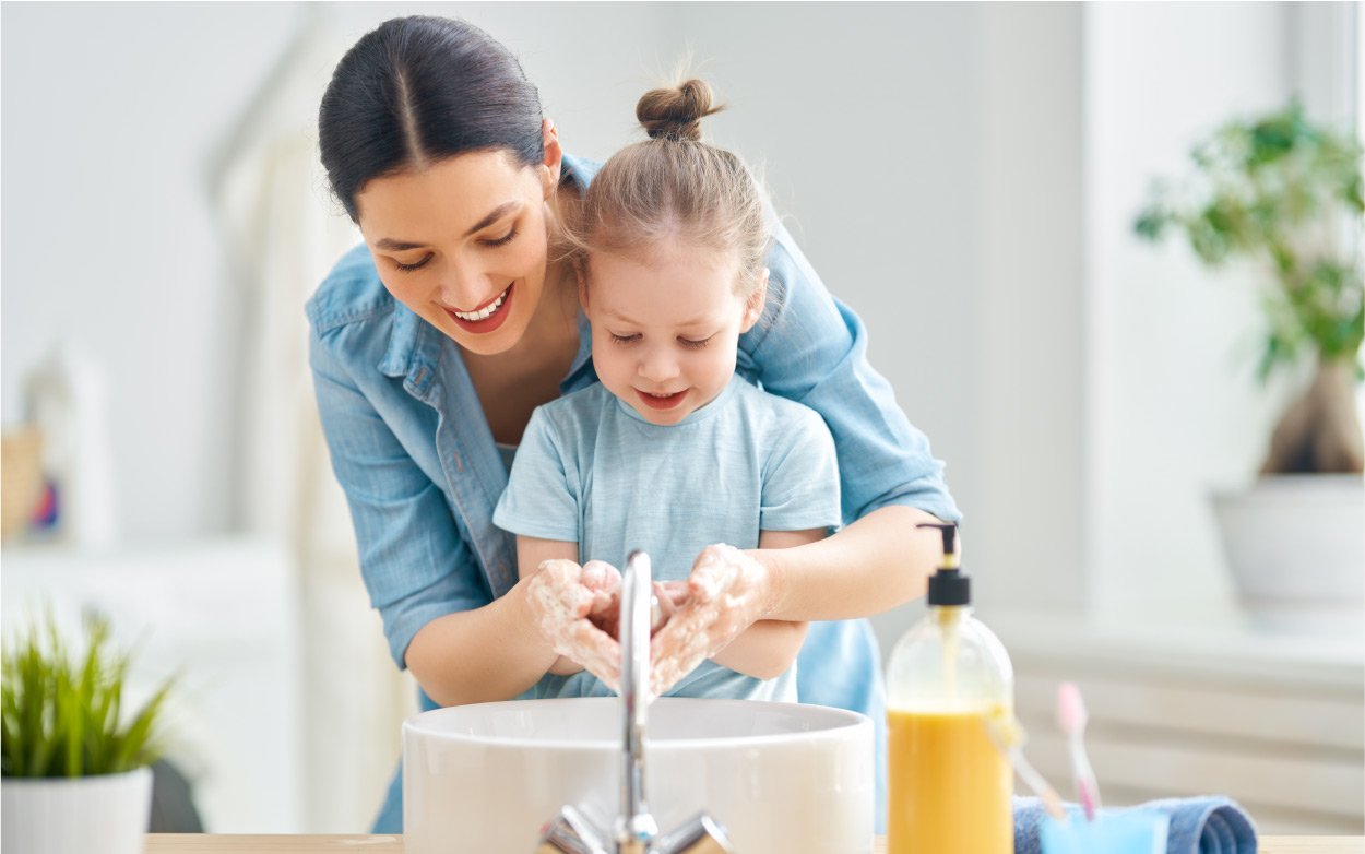 Famille qui se lave les mains au robinet